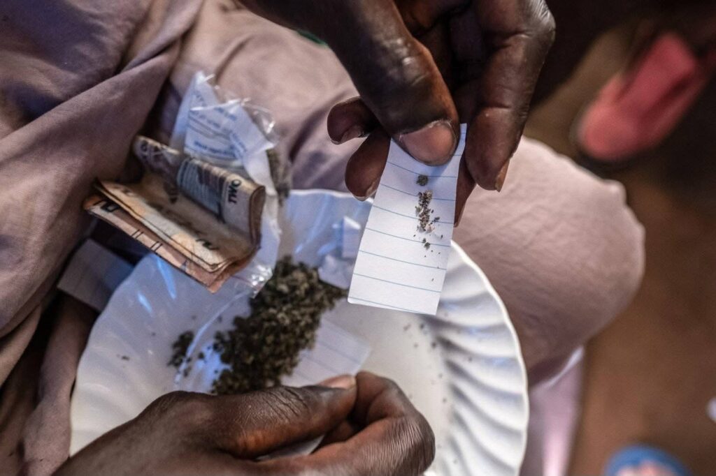 A seller rolling a joint of Kush. Photo Credit: Mustapha Kamara Junior-Facebook.