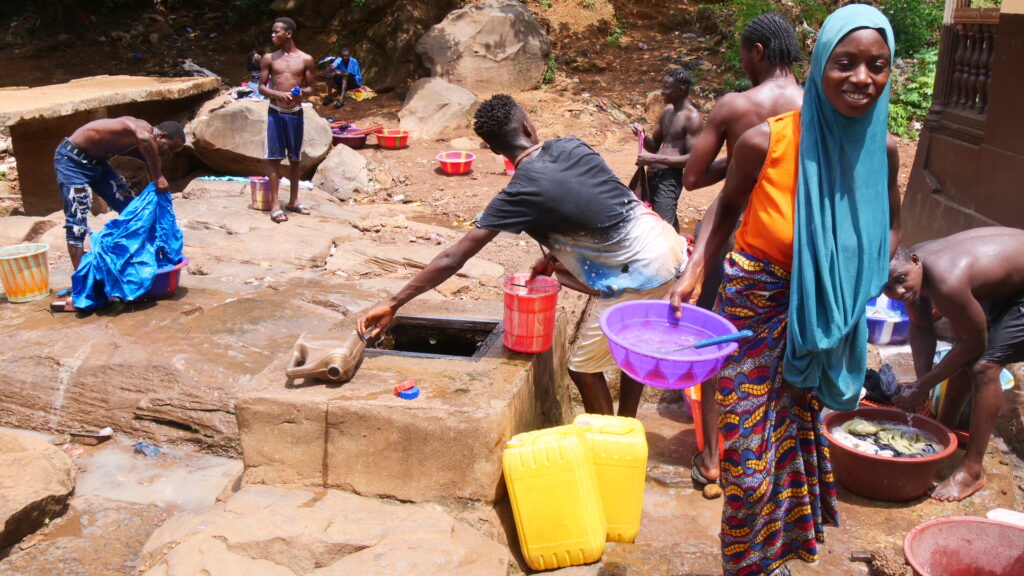 Residents fetching water at a community well. Photo Credit: Kemo Cham/Engage Salone