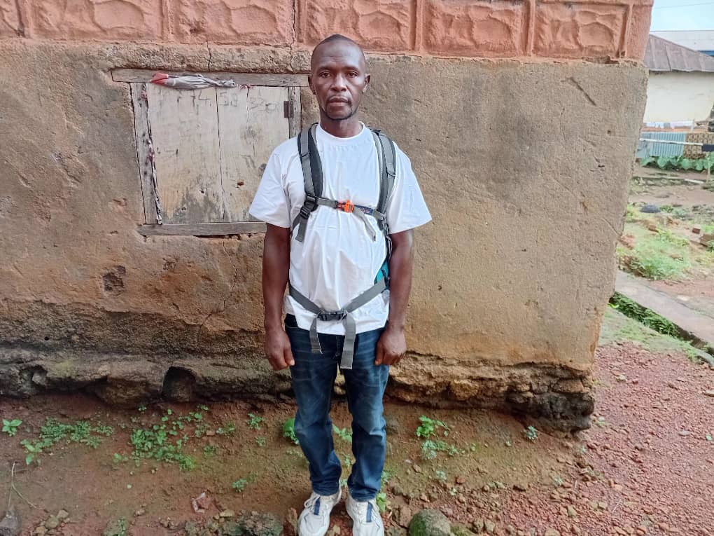 Victor Tengbeh standing by his former home in Yenga Town. Photo credit: Augustine Tamba Thomas/Engage Salone.